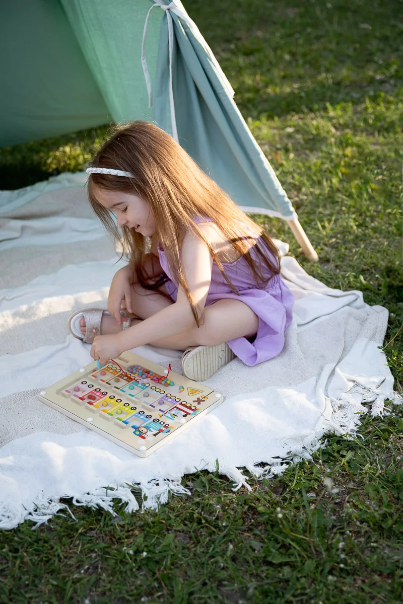 Kislány rajzol és alkot a piknik takarón